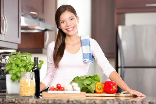 a woman smiling with vegetables in front