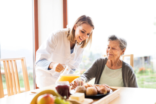 a nurse serving juice to an elderly